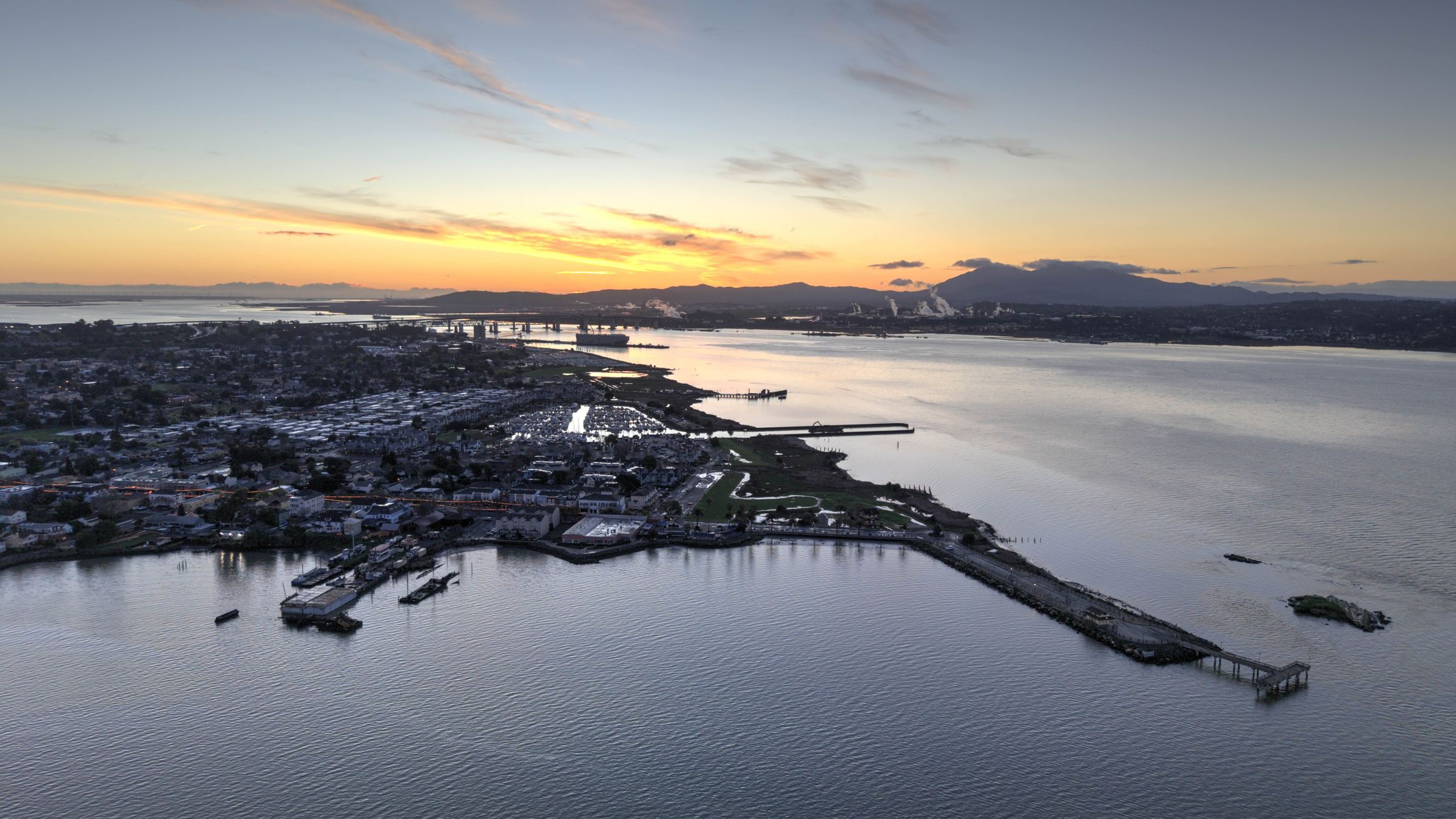 Aerial view of the Benicia waterfront at sunset, looking across the Carquinez Strait toward the hills